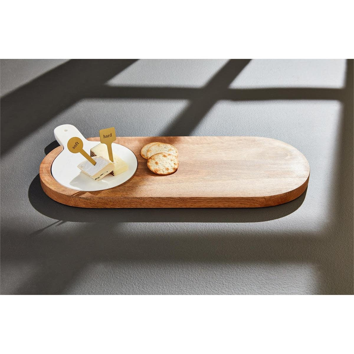 Rectangular mango wood serving board with inset white marble slab and two brass cheese markers.