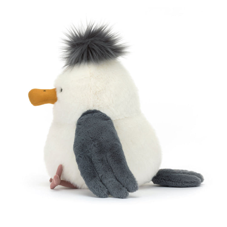Sitting Jellycat Chip Seagull plush toy with polyester fabric in grey-blue tones featuring a large beak and punk rock hair style.