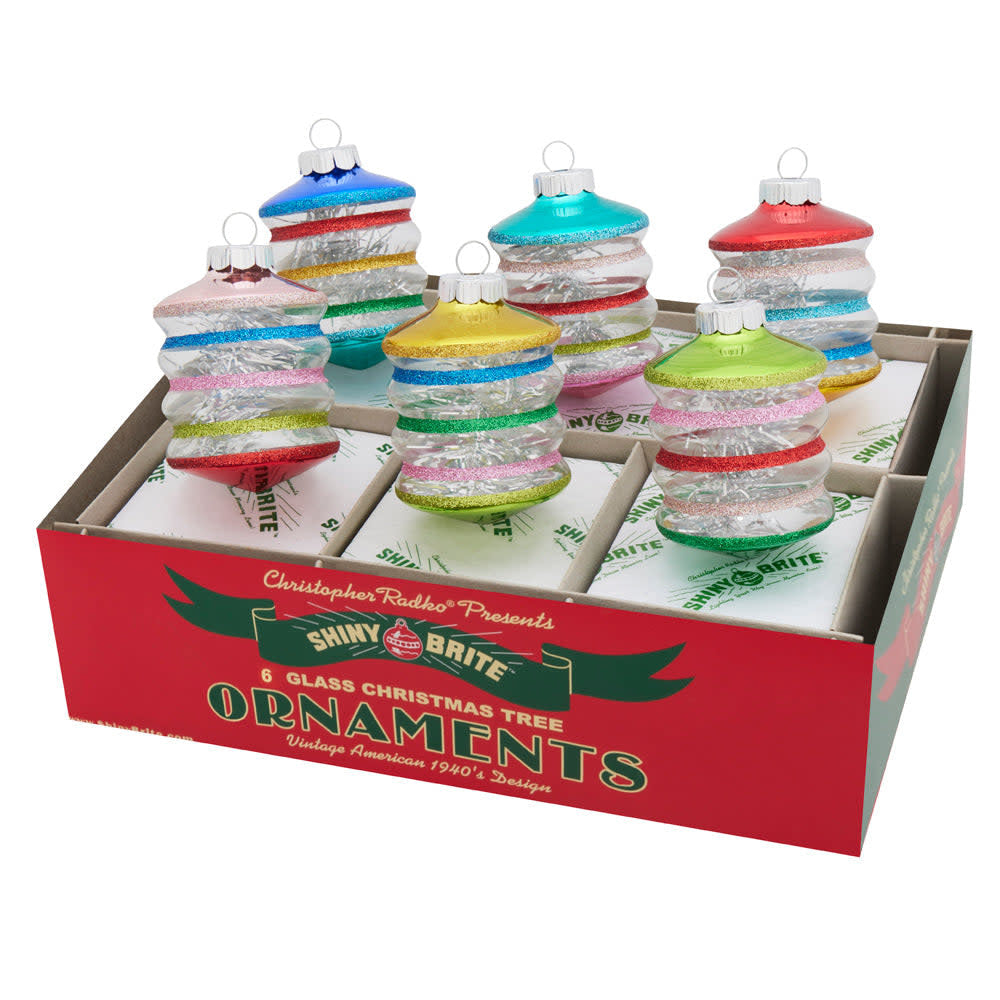 Three vintage-style lanterns with a Christmas confetti paper cutout pattern in red and green.