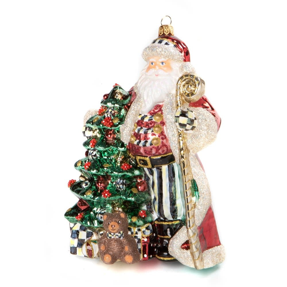 Hand-painted mouth-blown glass Christmas ornament featuring a Santa figure holding a staff with brass logo charm.