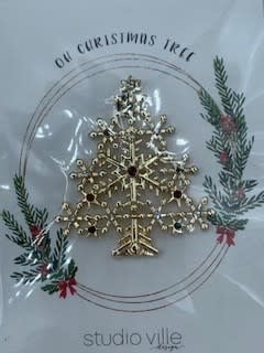 Metal Christmas tree pin with snowflake accents in a festive green color.