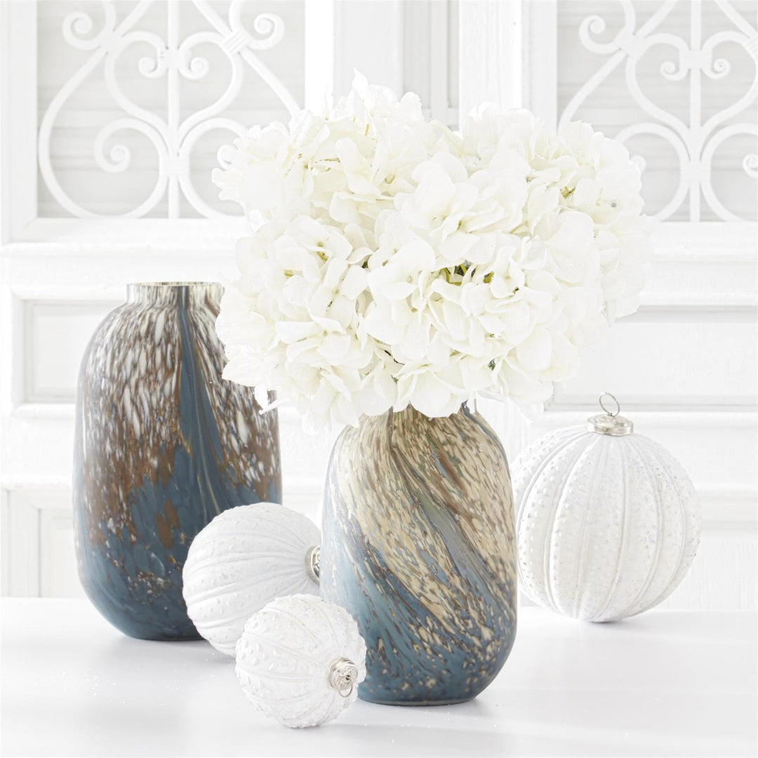 34 inch white glittered hydrangea stem in a blue and gold marbled vase with white ornaments.