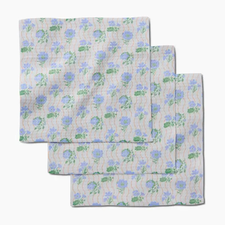 Set of three waffle weave washcloths with a blue floral pattern and orange wavy lines.
