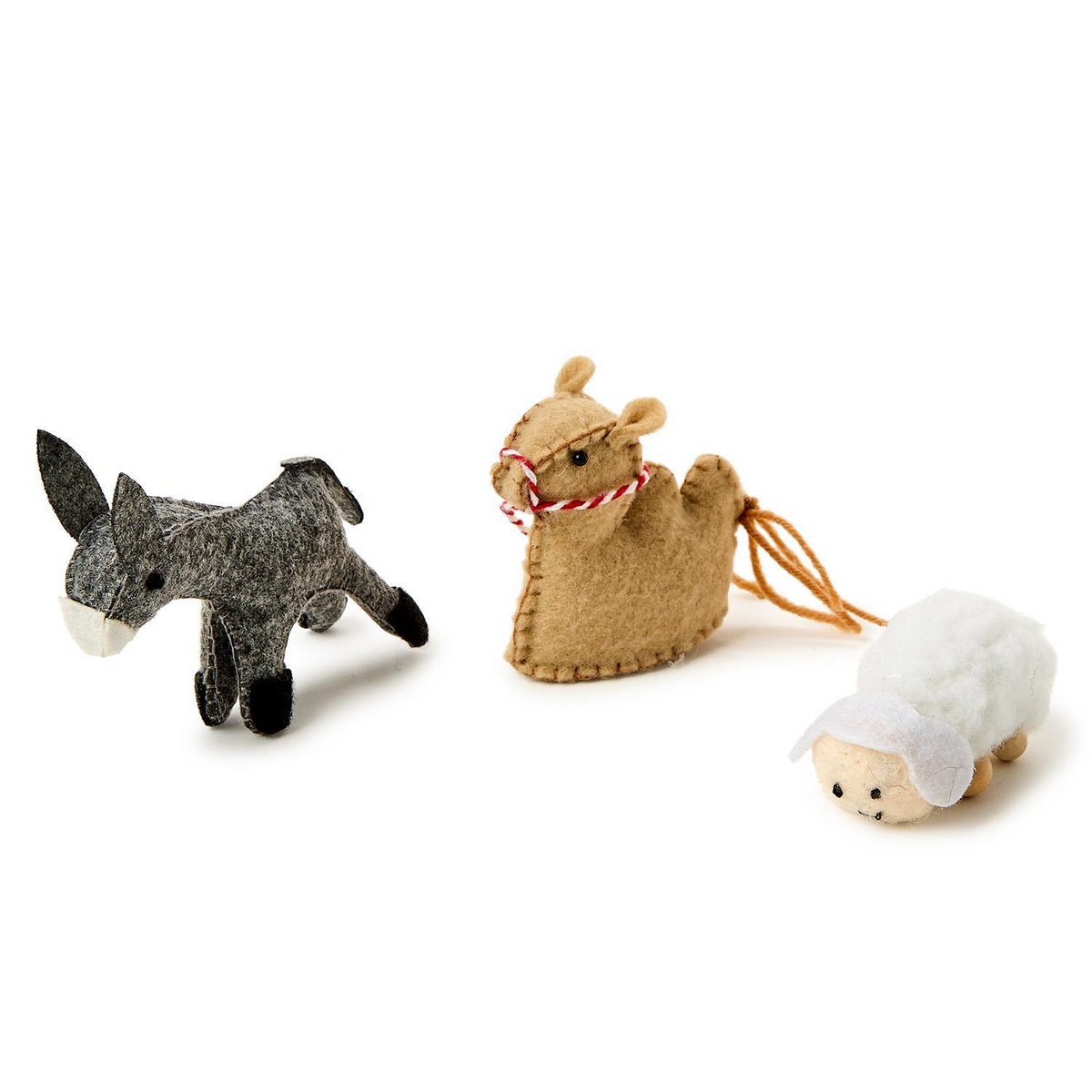 Three handcrafted felt animal figurines from a nativity set: a grey donkey, tan camel, and white sheep.