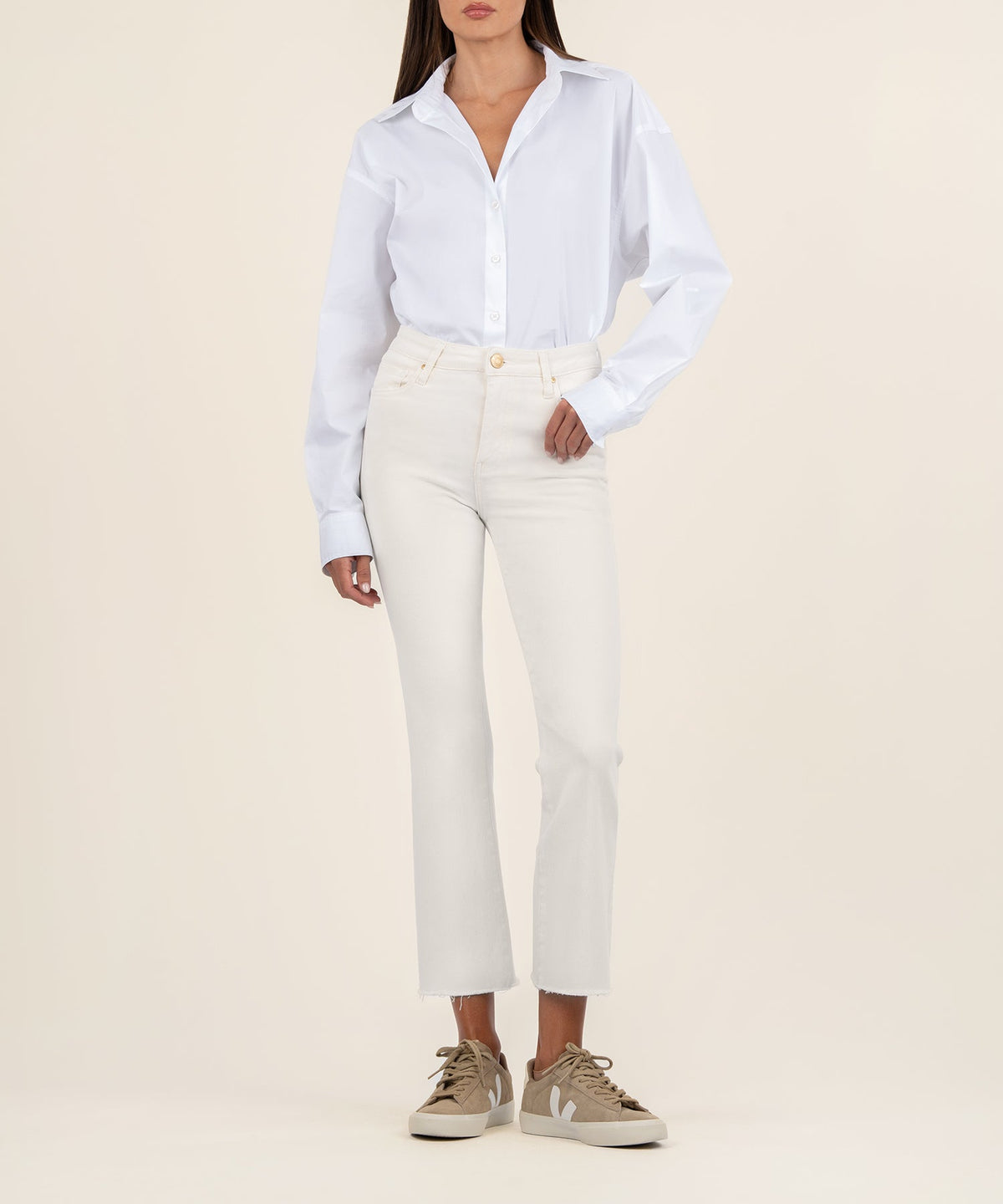 Woman wearing Kelsey raw hem high waist ankle flare jeans in off-white with a white button-down.