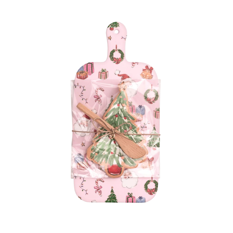Pink melamine paddle board set with Christmas tree napkins and a wooden spreader.