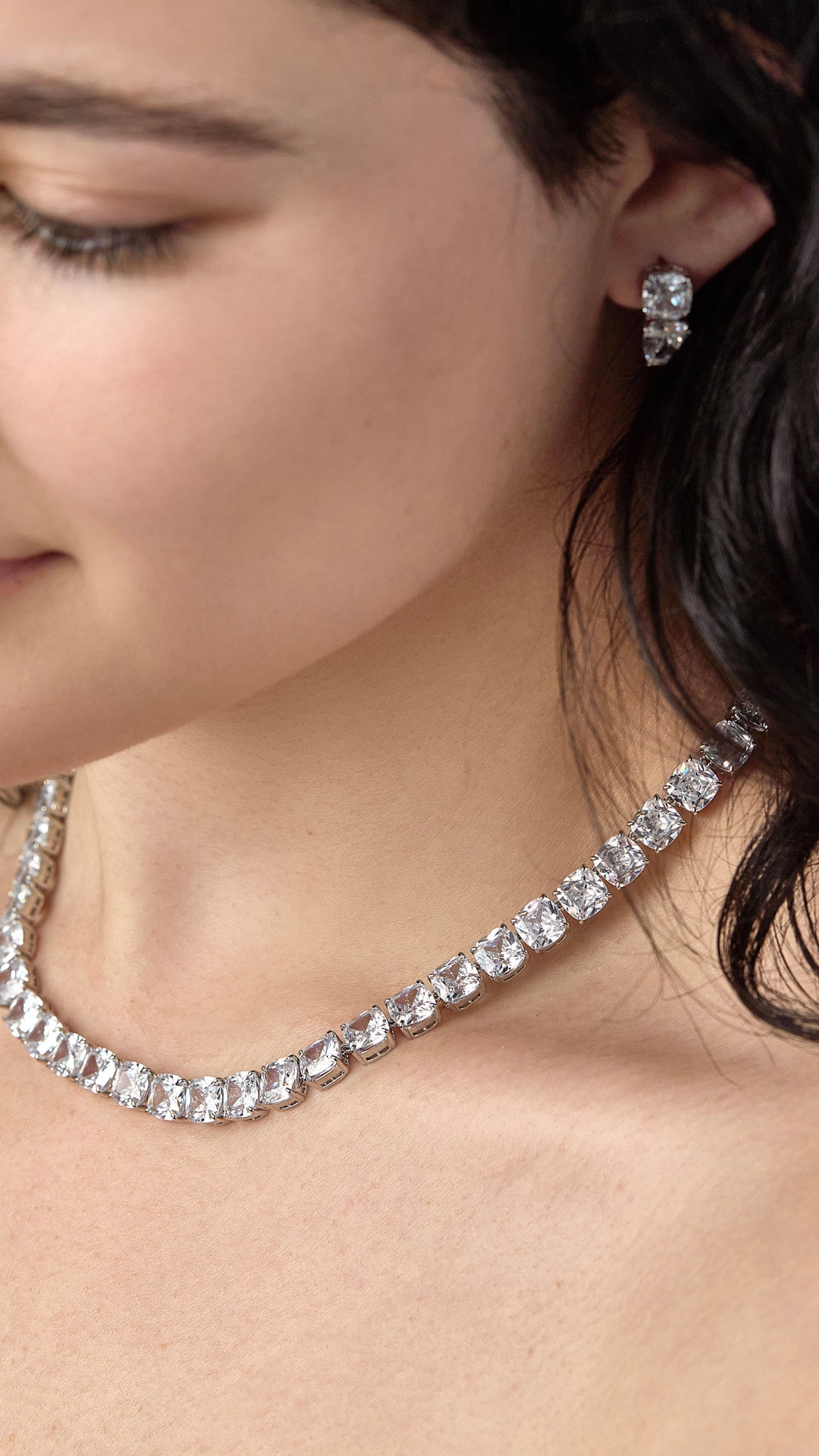 Silver-tone tennis necklace with cushion-cut clear cubic zirconia stones in a box closure.
