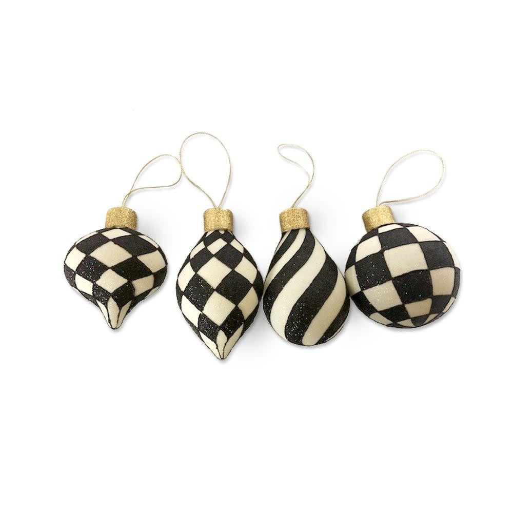 Handmade glass ornament with black and white patterns on a clear body topped with a large golden cap.