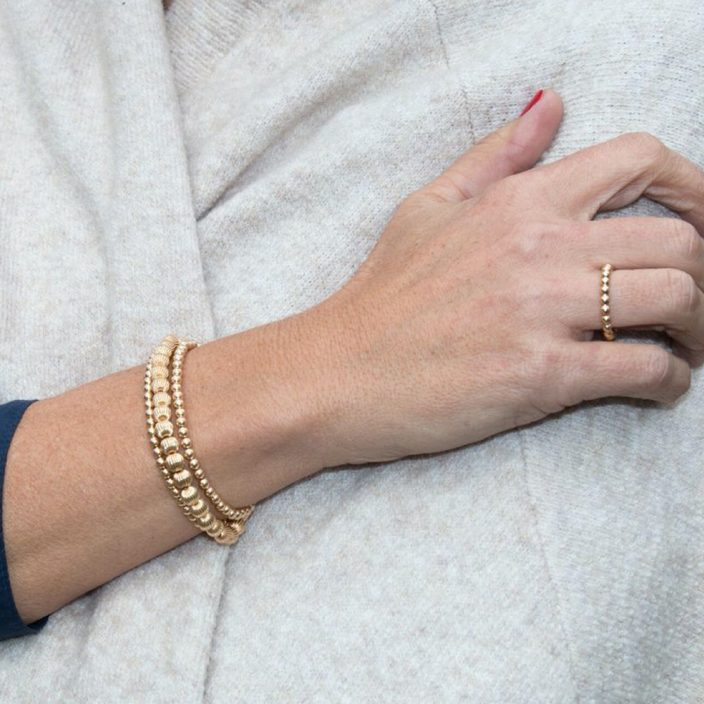 Classic gold-filled ring with a continuous beaded texture in a circular band silhouette.