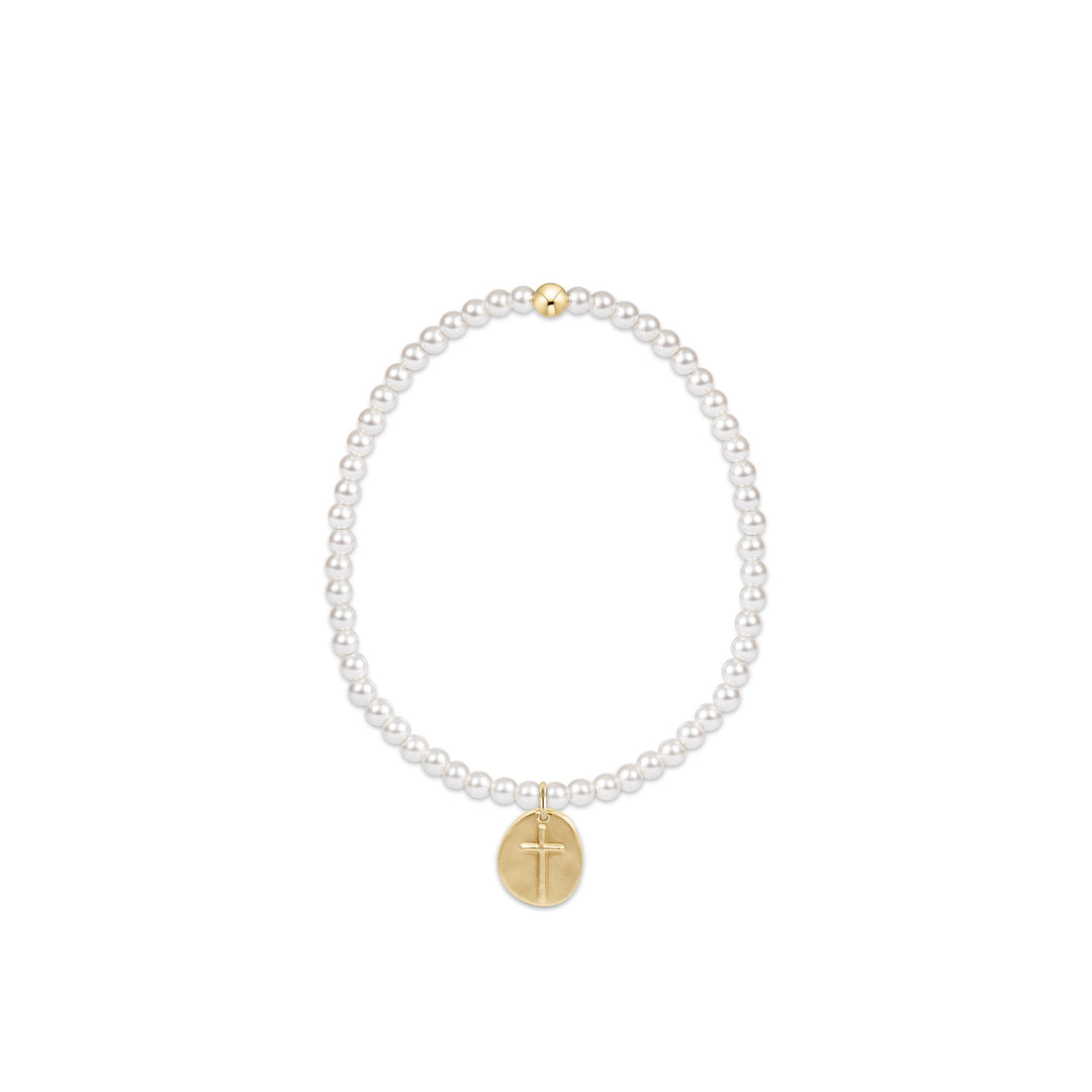 Stretch bracelet with white pearl beads and a small gold cross charm