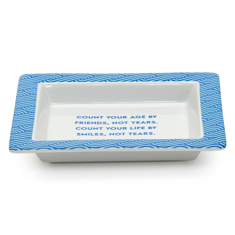 Porcelain desk tray with colorful classic wise saying quote printed on white surface.