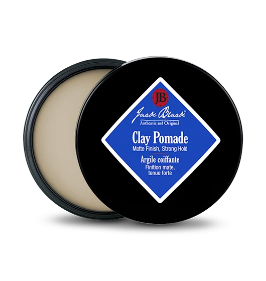 A small jar of matte black clay pomade with a silver lid.