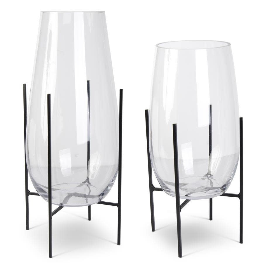 Clear glass floating vase on a dark metal stand with cylindrical shape