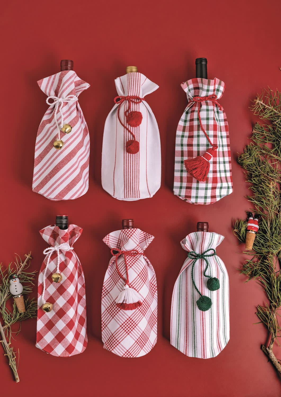 Cotton cloth wine bag in natural fabric with a decorative tassel tie closure.