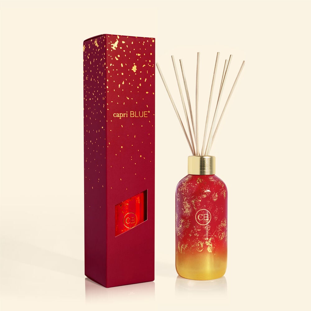Apple Cider Social Glimmer reed diffuser in a clear glass vase with floating decorative elements.