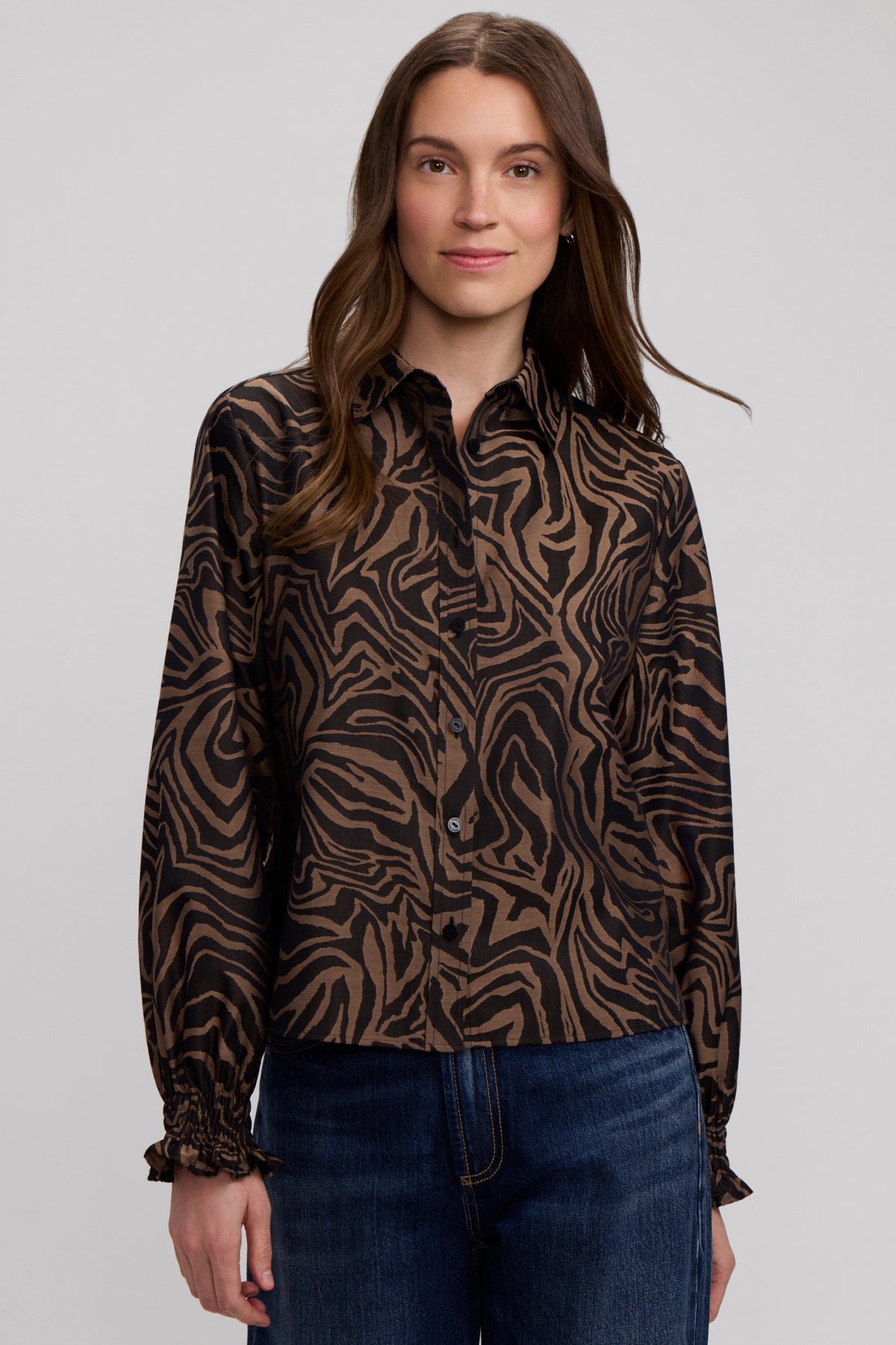 Woman wearing the Vivienne Long Sleeve Zebra Shirt with abstract brown and black print.
