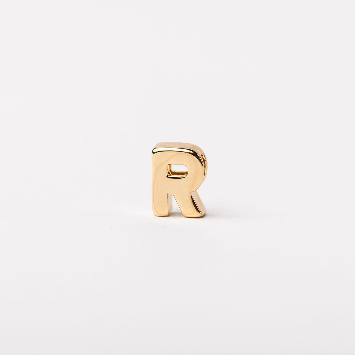 Gold-toned letter R charm with a polished finish on a plain white background.
