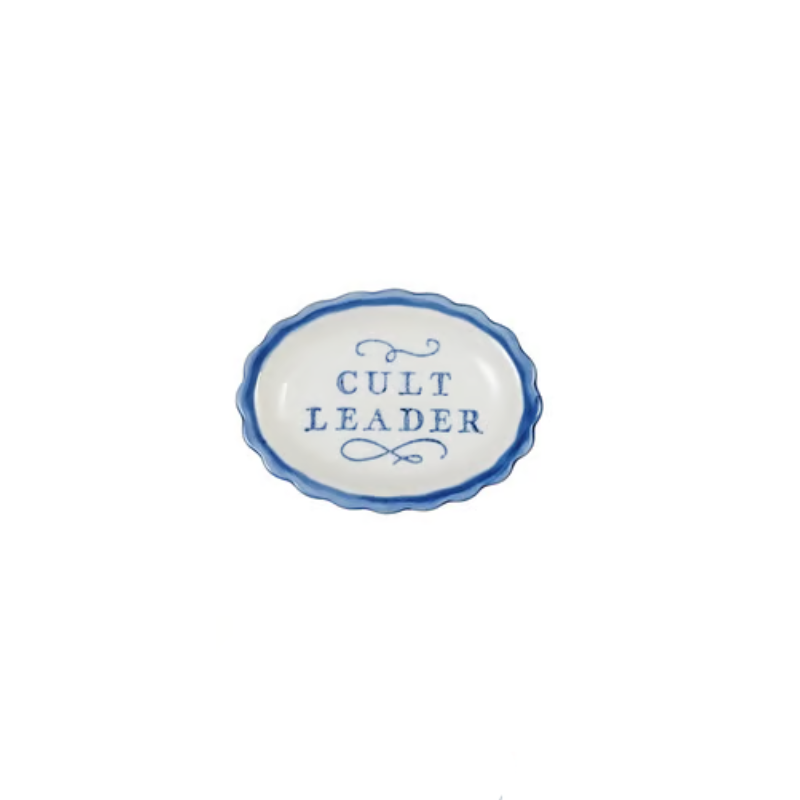 White stoneware scalloped dish with blue border and blue text reading CULT LEADER.