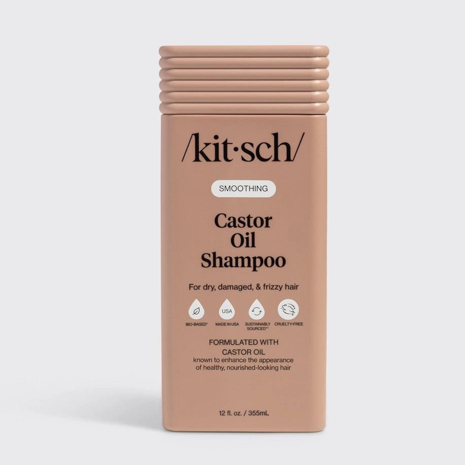 Bottle of Smoothing Castor Oil Shampoo with a white label against a neutral background.