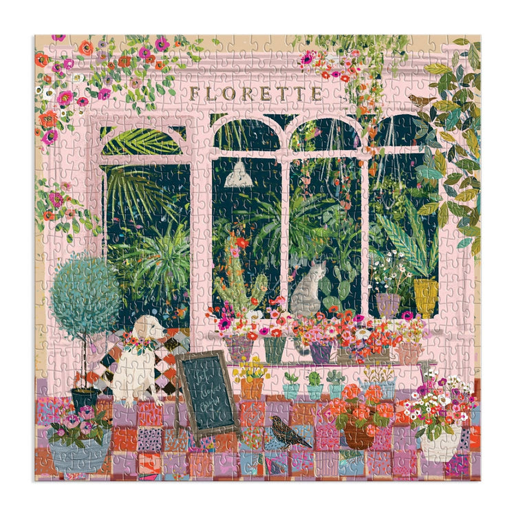 Florette 500 piece puzzle featuring a pink flower shop facade with a window display of plants, a dog, and a cat.