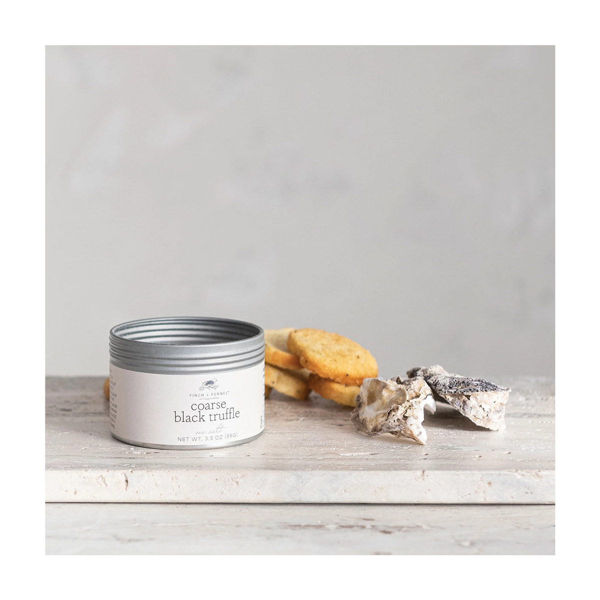 Coarse black truffle sea salt in a clear glass jar with a white lid