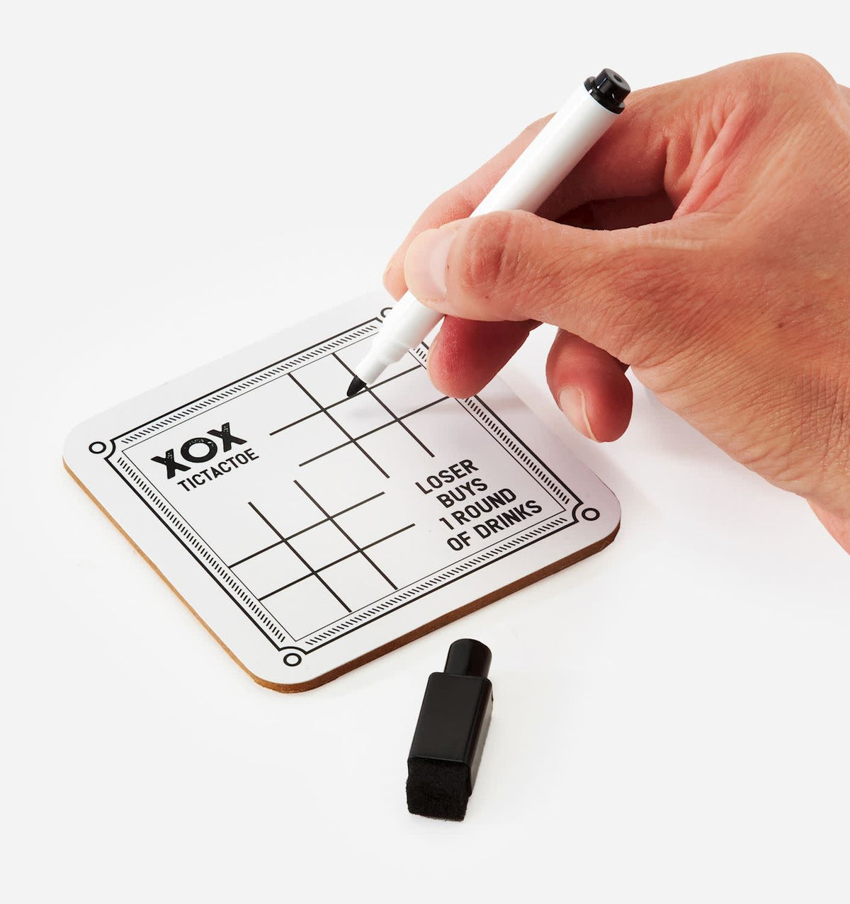 Four plastic drinking game coasters with paper inserts featuring different patterns inside a cardboard box.