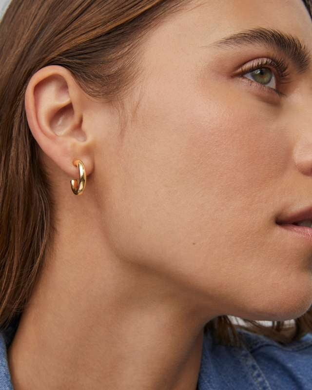 Silver-tone minimalist huggie hoop earrings with a small ear post closure.
