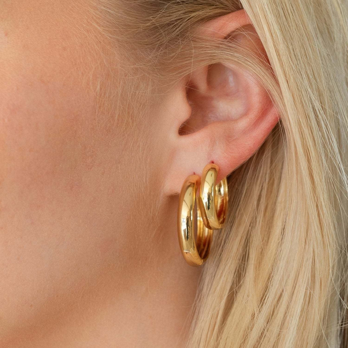 Set of three graduated huggie earrings in gold-tone metal with rhodium plating.