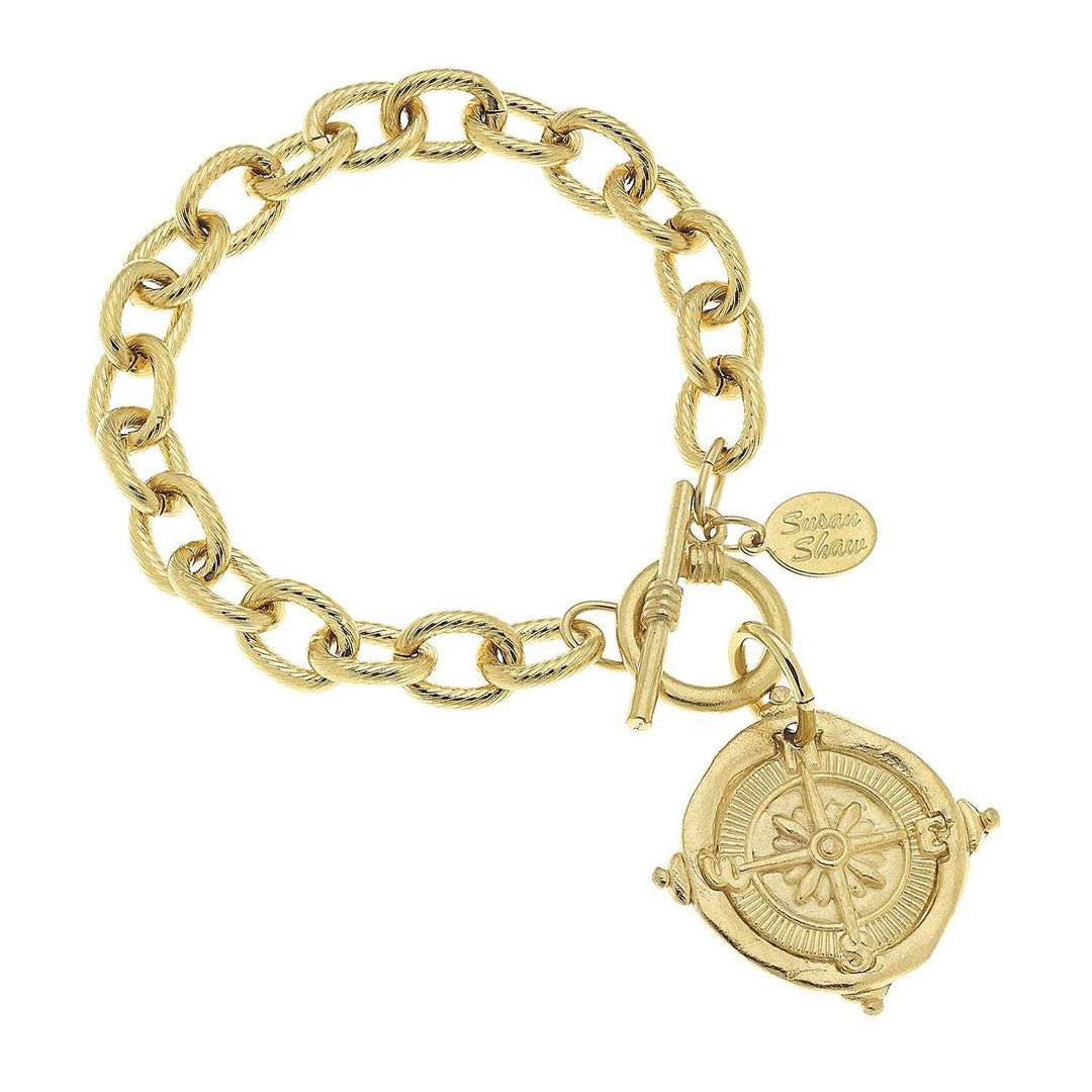 Gold triple-plated compass toggle bracelet with dangle charm on an 8-inch chain.