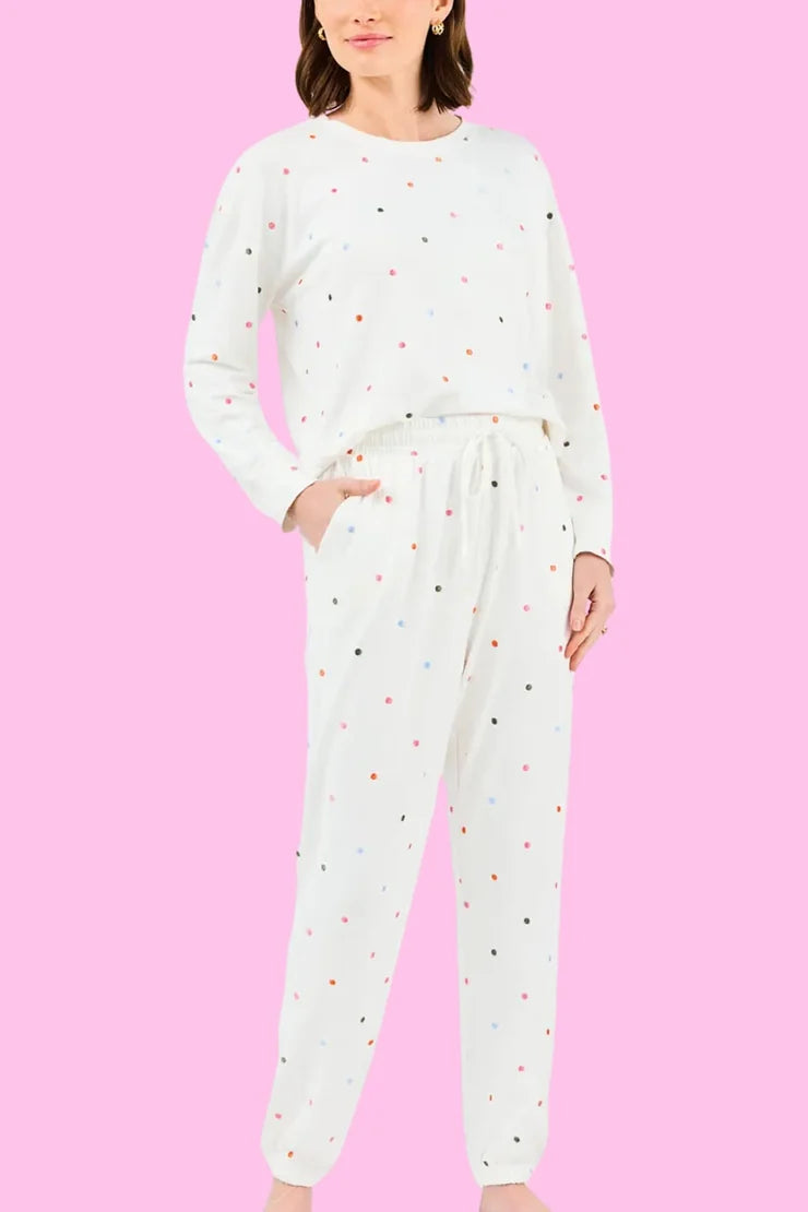 Woman wearing the Sophie Jogger Set, a white long-sleeve top and joggers with multi-color dots.