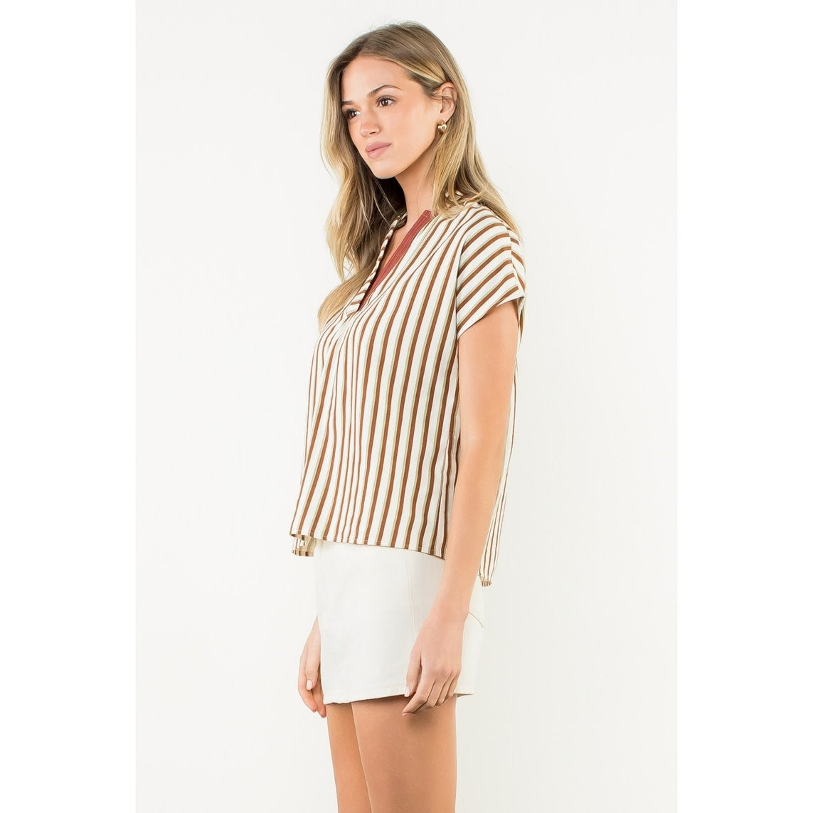 Side view of a woven striped top with contrast V-neck trim in polyester nylon fabric.