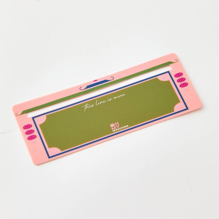 Coral-colored plastic Mahjong line finder tool with a compact clip-on silhouette.