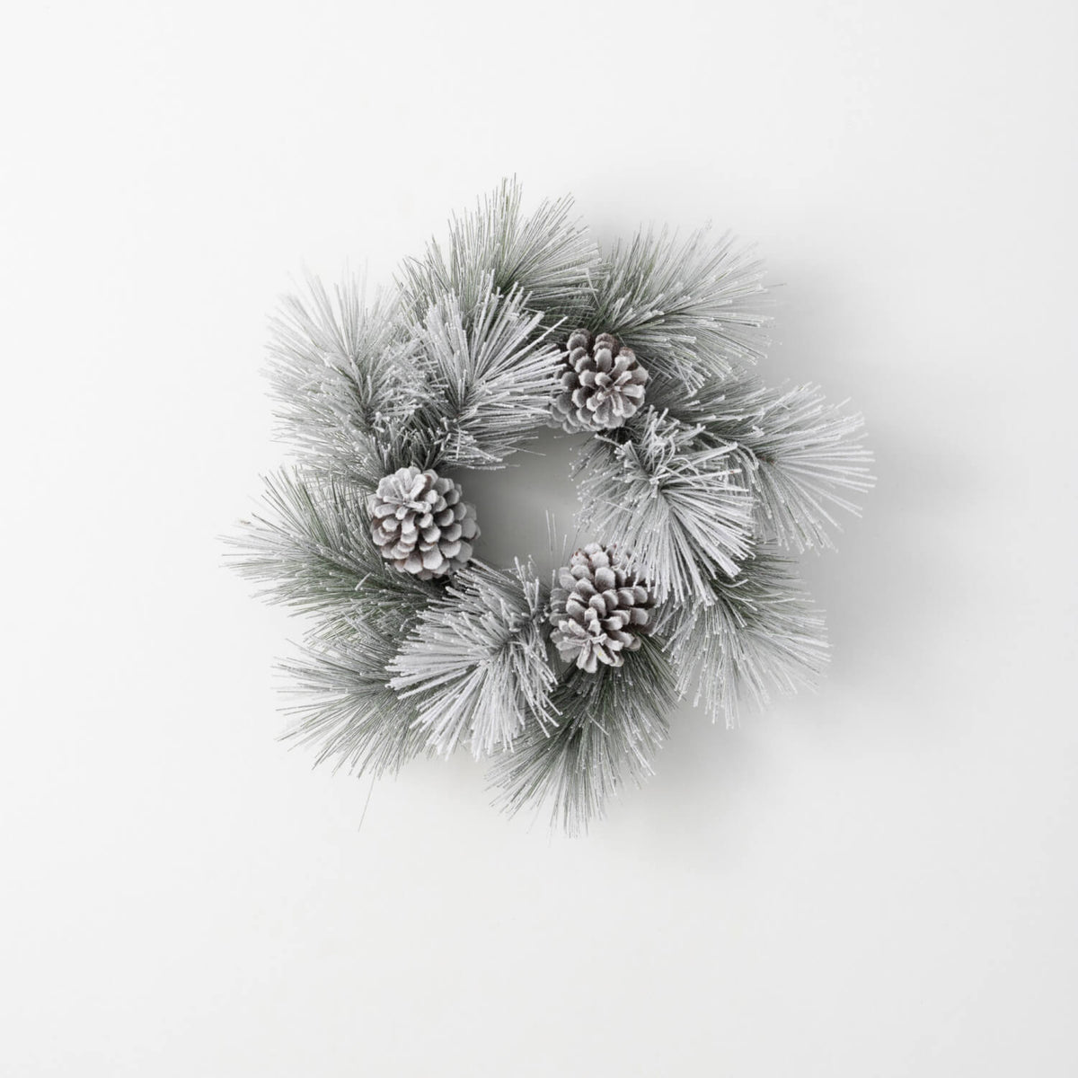 6.5-inch flocked green pine ring wreath with three frosted pinecones on a white background.