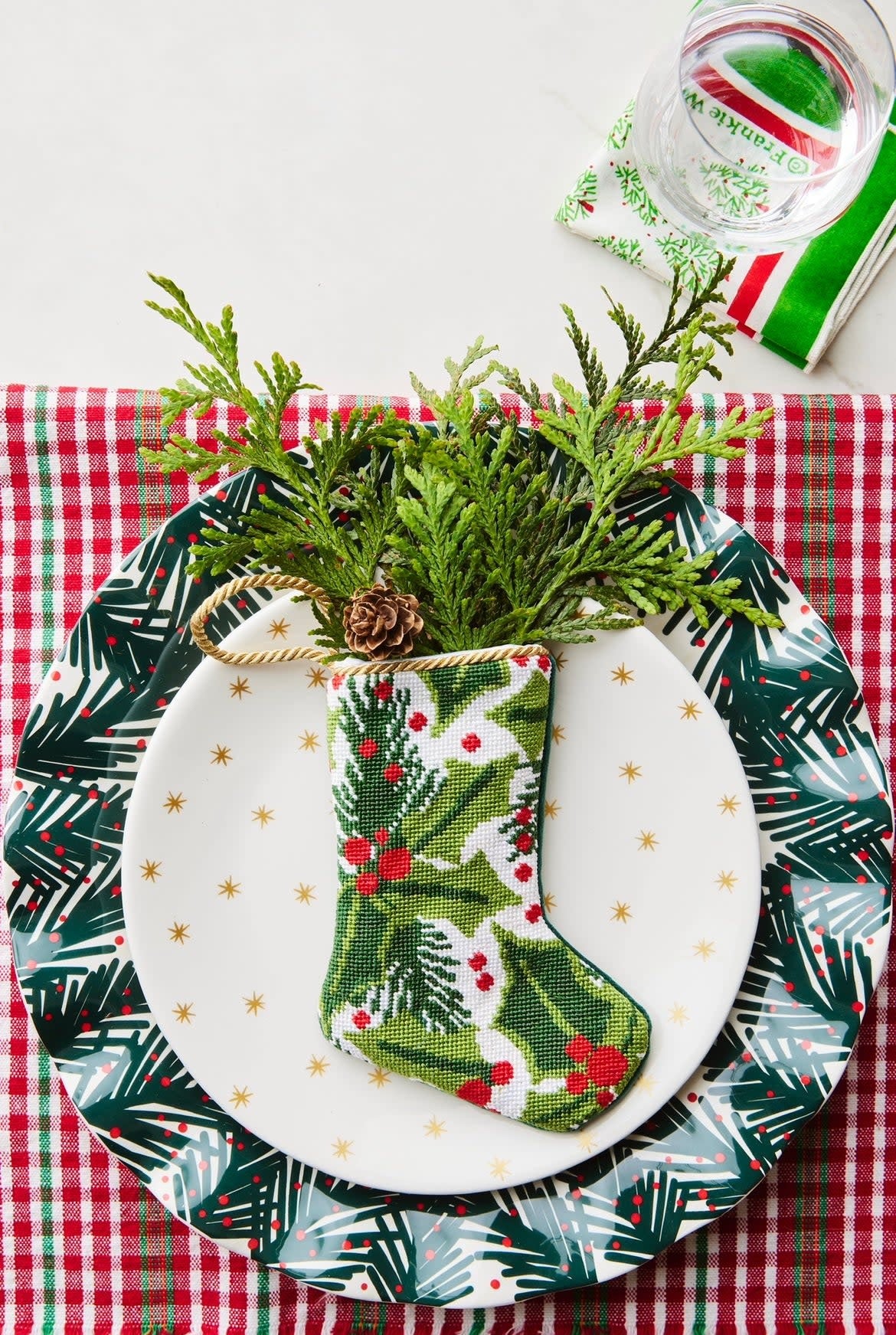Red fabric stocking decorated with green balsam branches and red berries.
