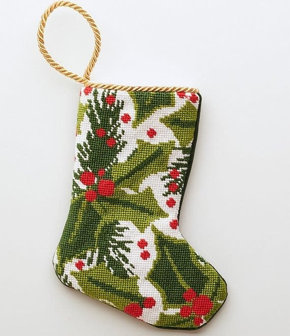 Red fabric stocking decorated with green balsam branches and red berries.