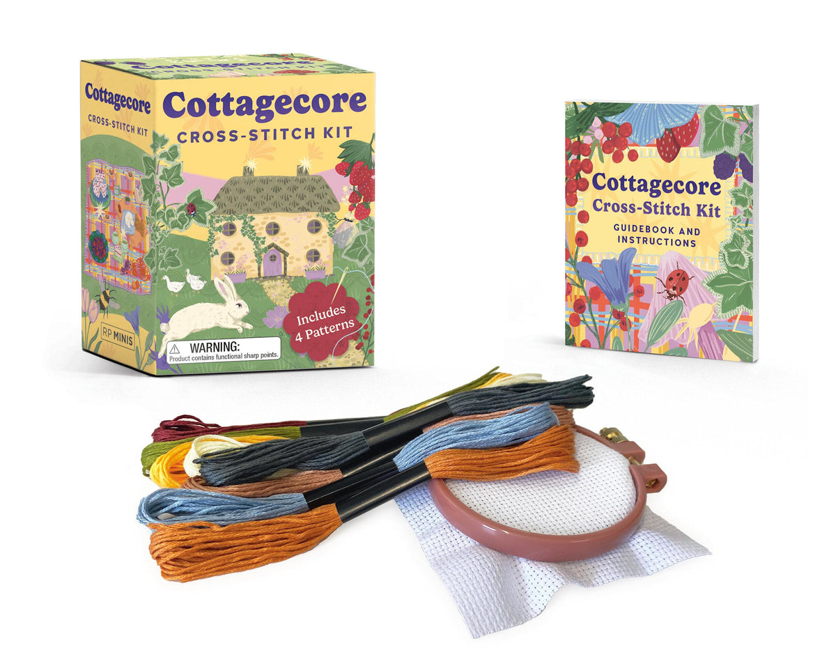 Cottagecore cross-stitch kit with cotton Aida cloth, embroidery hoop, needles, thread skeins, and a details book featuring mushroom cottage patterns.
