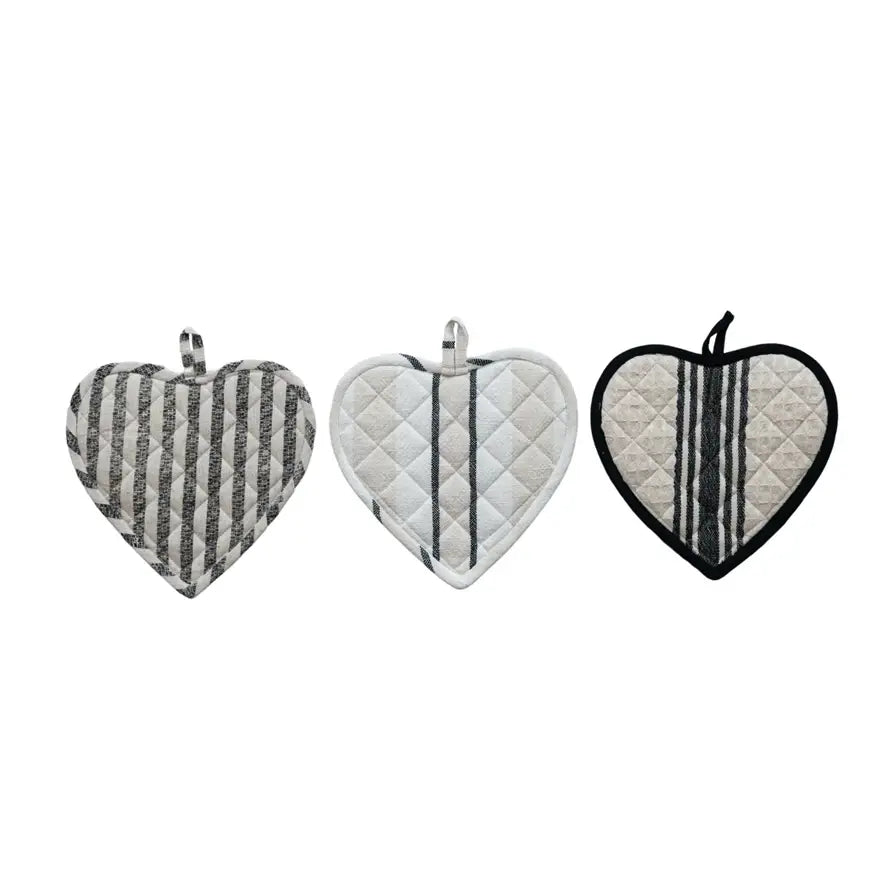 Cotton quilted heart-shaped pot holder in natural fabric color with visible stitching.