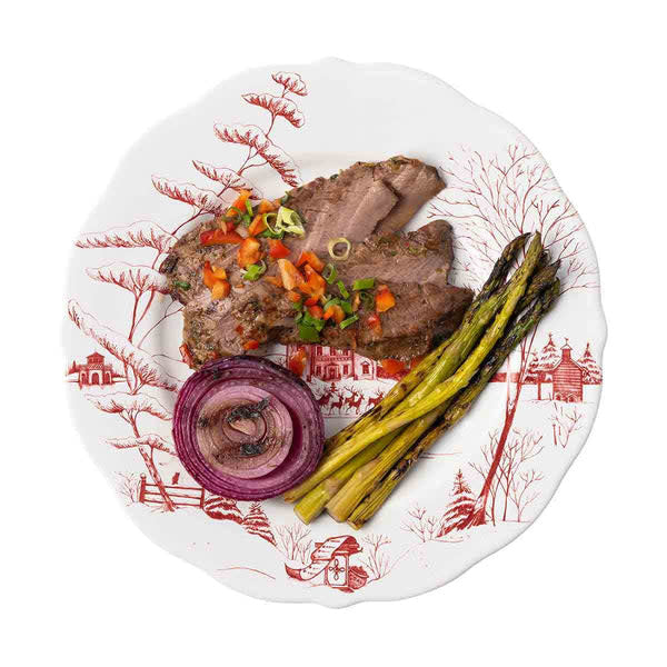 Ceramic dinner plate with scalloped edge featuring a festive ruby winter scene.