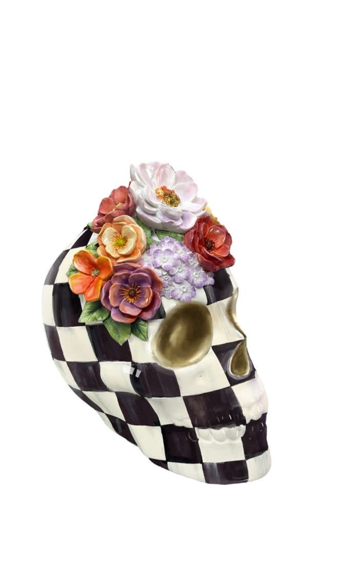 Resin decorative skull with black-and-white checkered background and cascading vibrant floral accents.