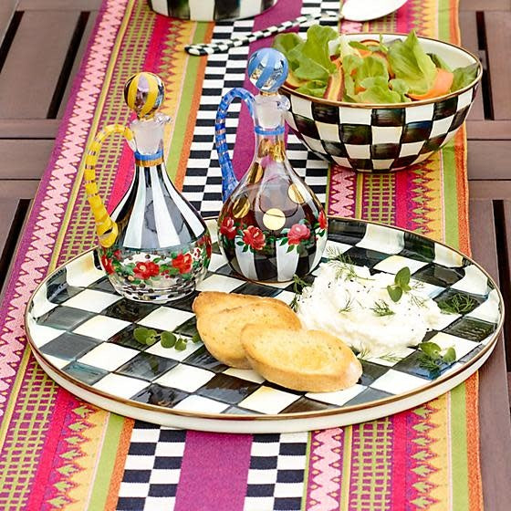 Round Courtly Check enamel tray with hand-glazed steel surface, bronzed rim, and checkered pattern.