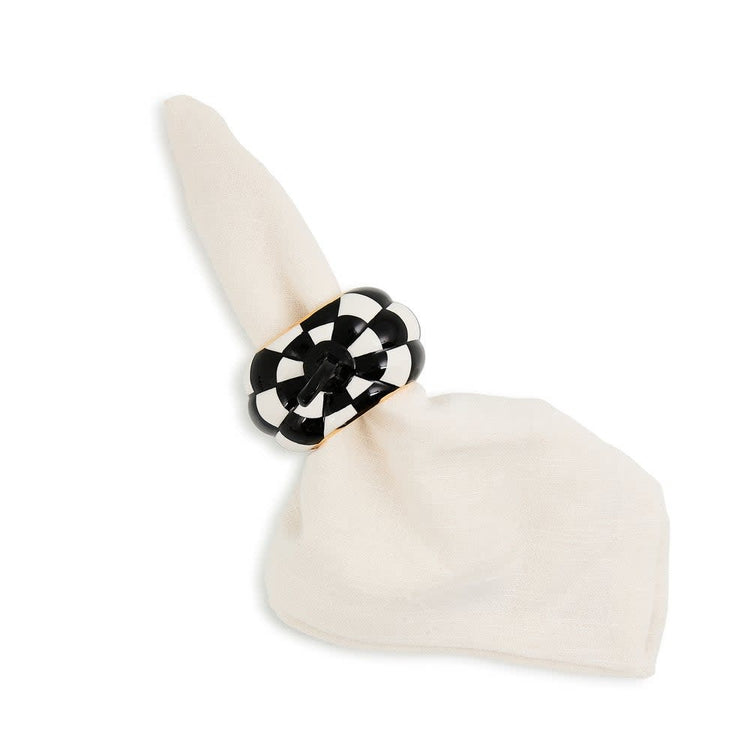 Set of four black and white ceramic pumpkin-shaped napkin rings with a checkered pattern.