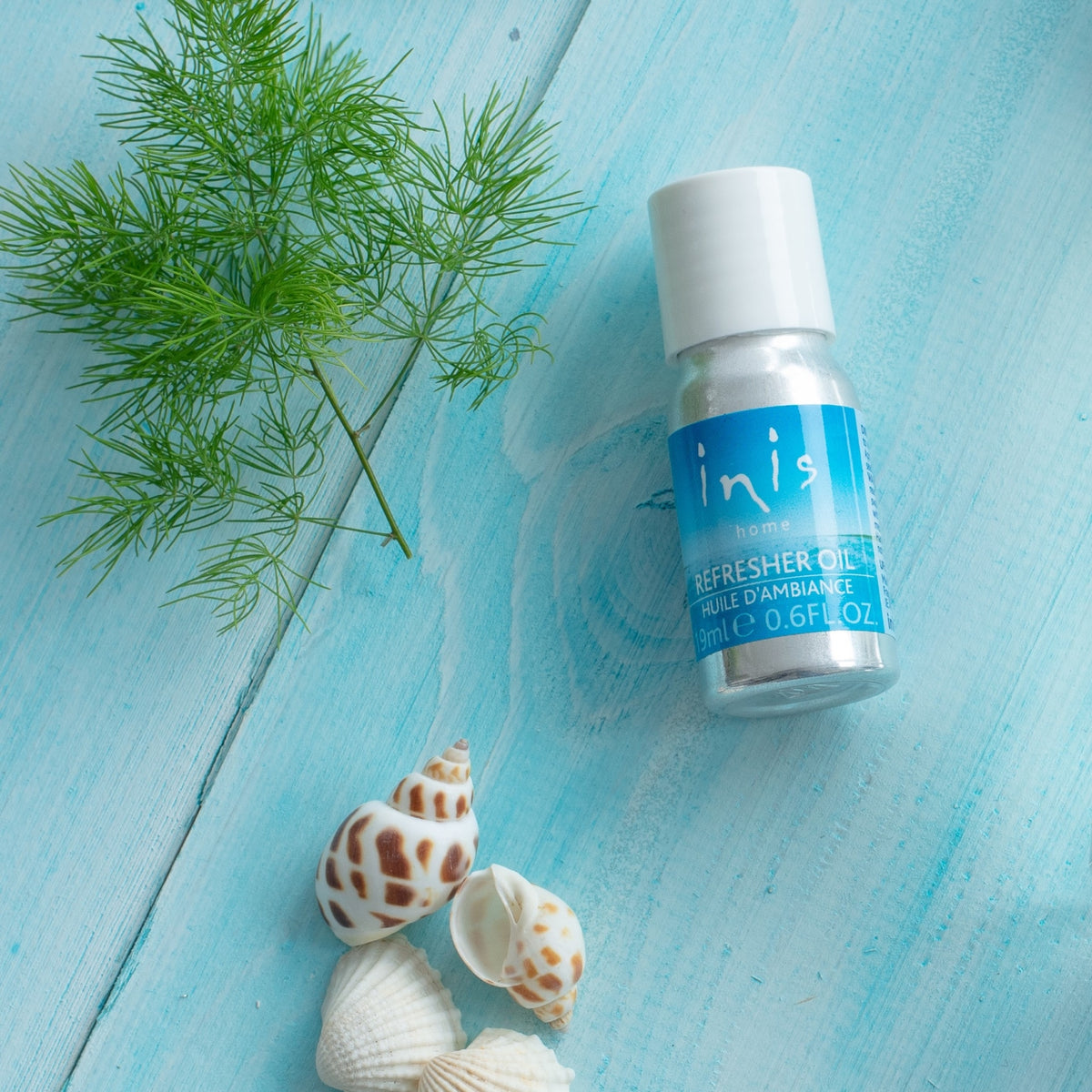 Bottle of Inis Energy Of The Sea home fragrance refresher oil in a clear glass container with white liquid.