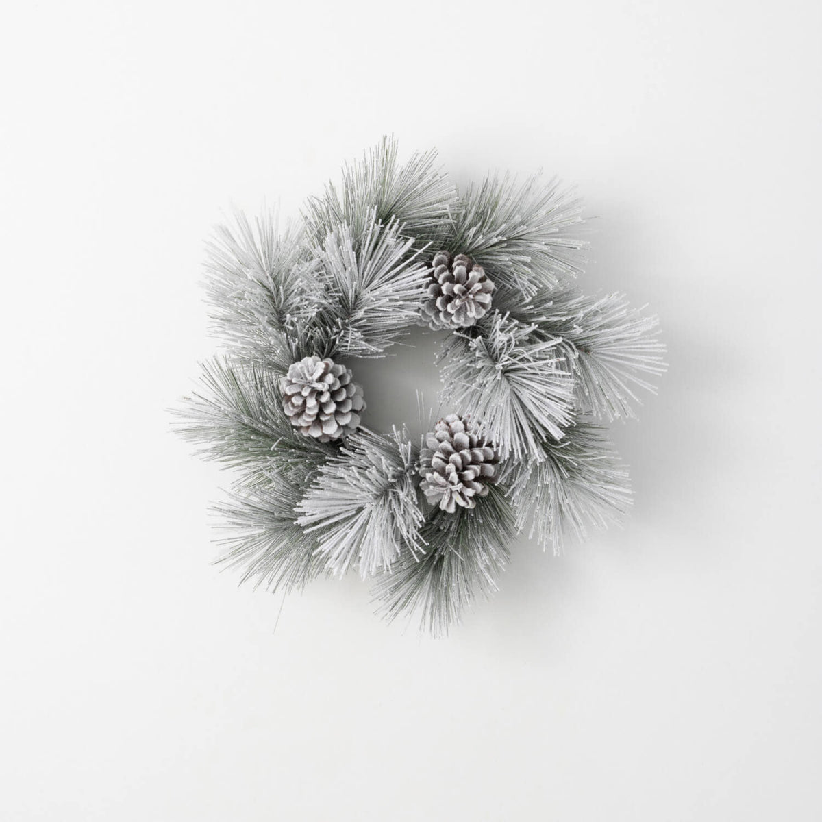 Green flocked pine ring wreath with faux snow-dusted cones