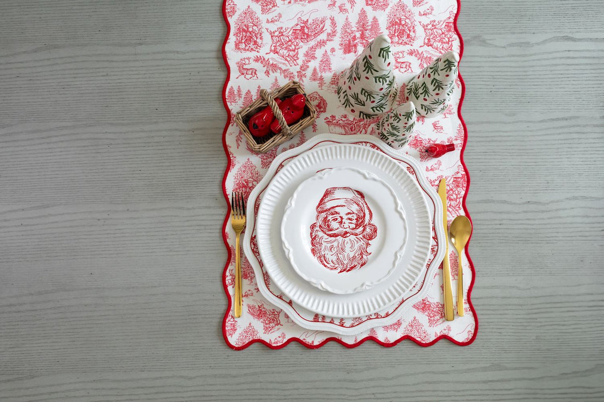 Two small red dolomite pocket cardinal figurines in a miniature woven basket on a holiday table.