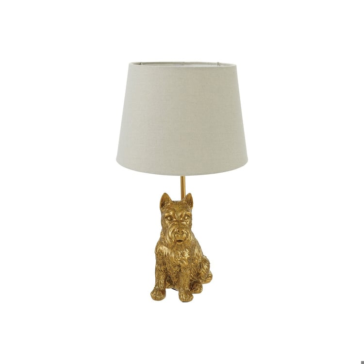 Resin Scottie shaped table lamp with an antique gold finish and a neutral fabric drum shade.