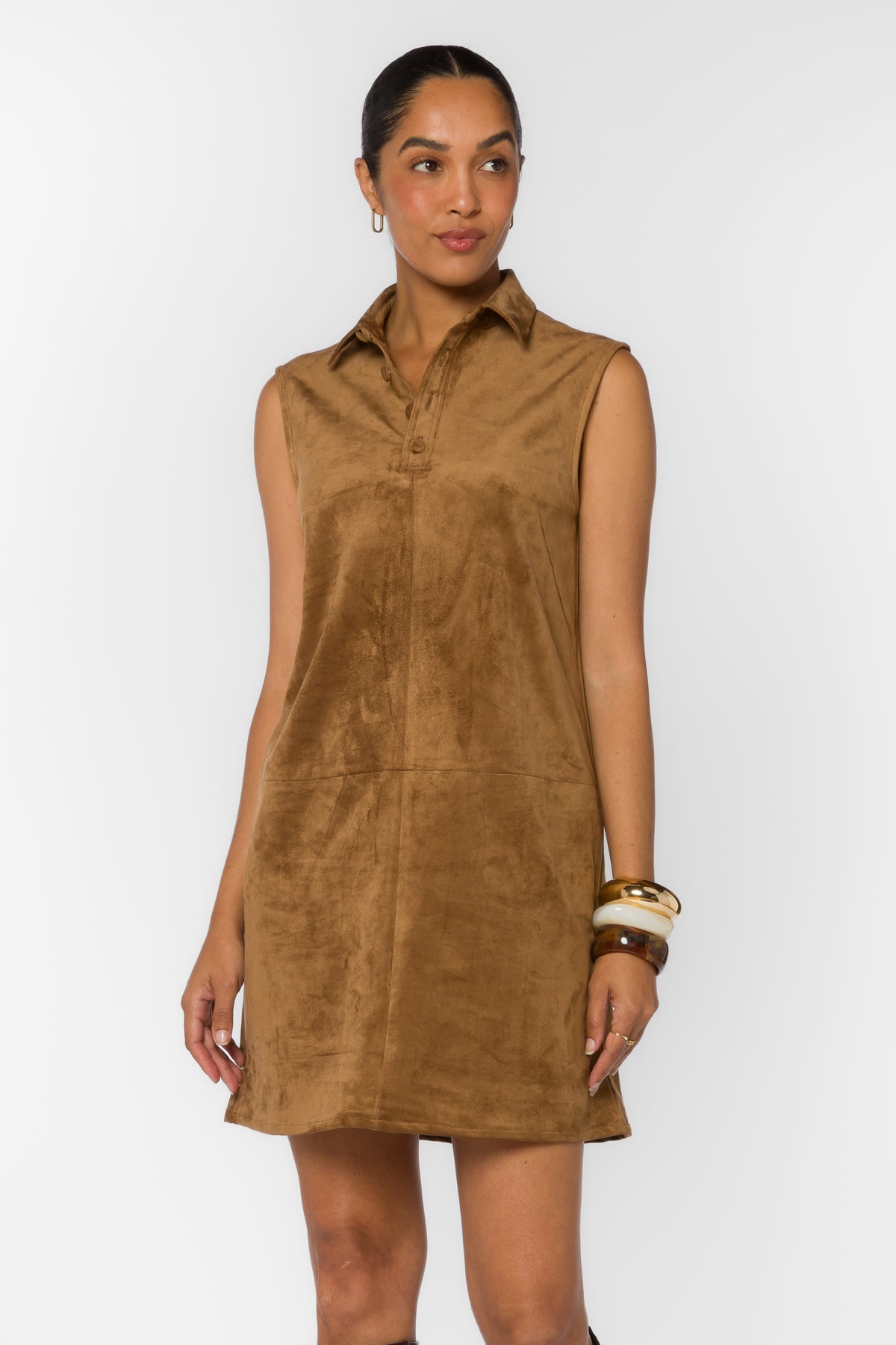 Woman wearing the Novi Mini Dress, a brown faux suede sleeveless shift dress with a collar.