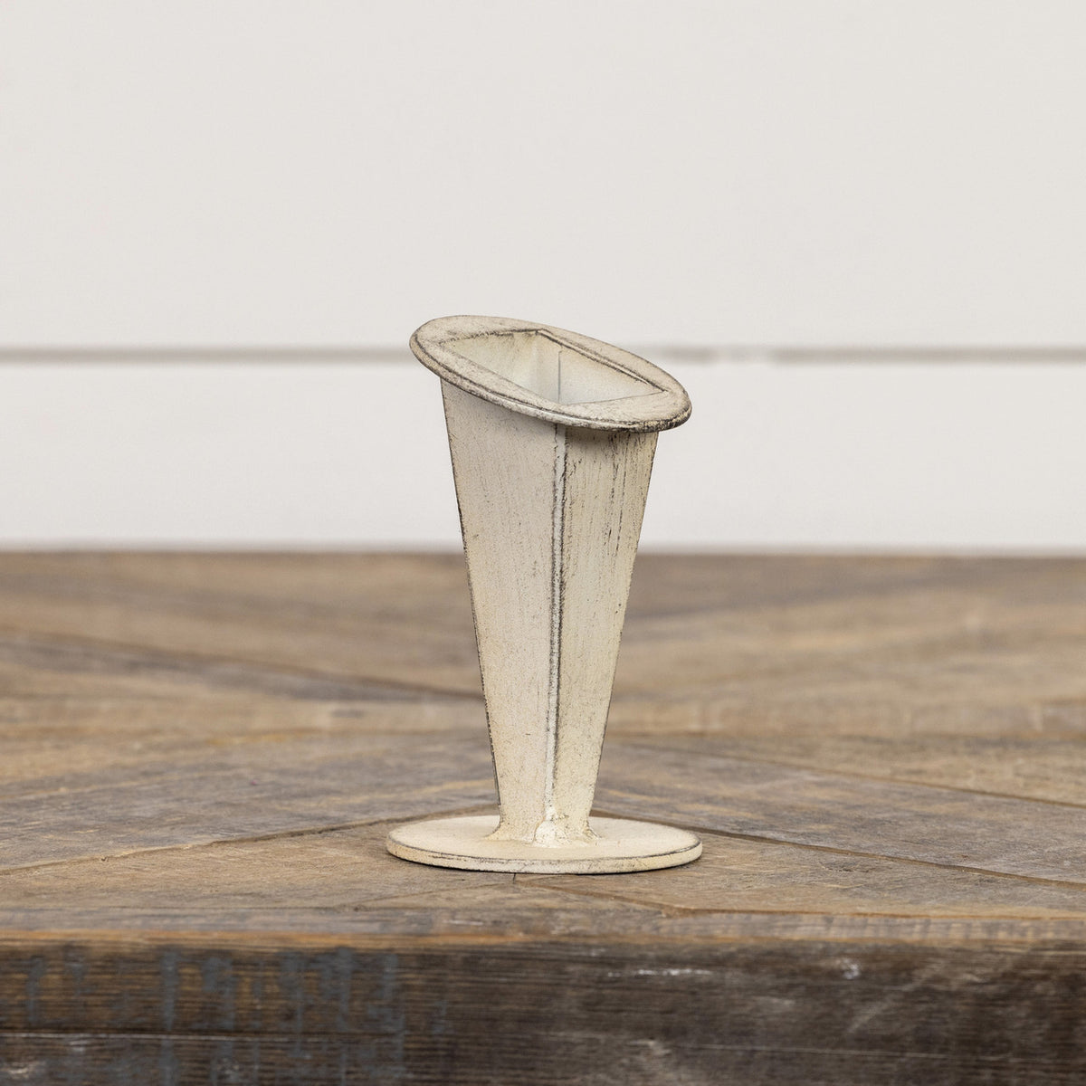 4-inch white tapered metal vase with a distressed finish on a wooden surface.