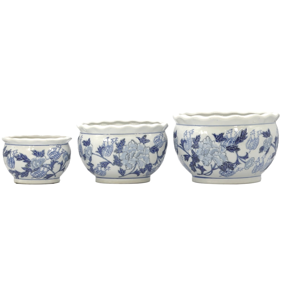 Set of three round blue and white ceramic Chinoiserie planter pots with fluted rims and floral art.