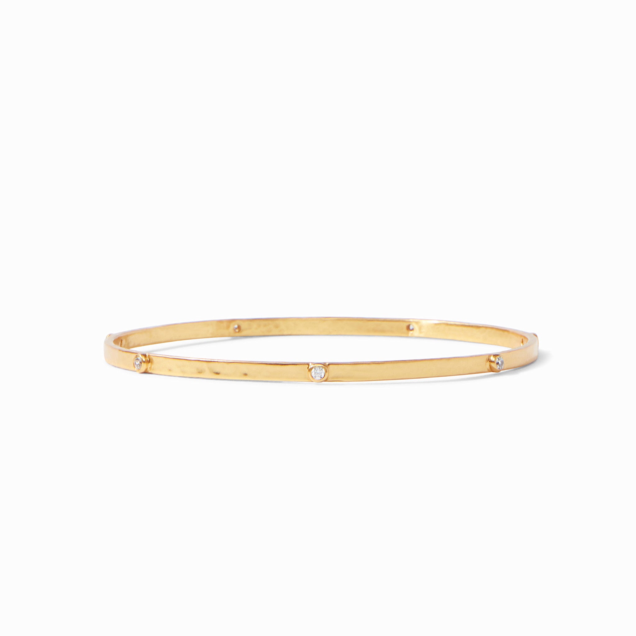 Lightly hammered silver bangle with cubic zirconia gemstone stations in a crescent pattern.