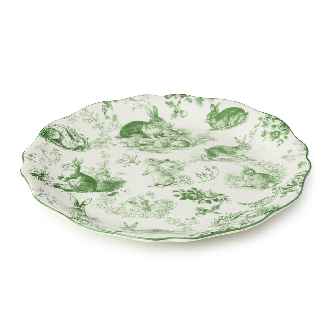 Round ceramic platter with scalloped rim featuring delicate green French garden artwork on a white background.